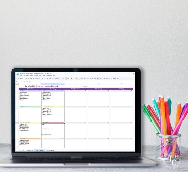 A computer and pencils on a desk with the computer open and displaying a build your own Weekly Phonics Lesson Plan template in Google Slides